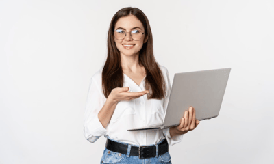 Female corporate professional smiling and showing various types of surveys on laptop